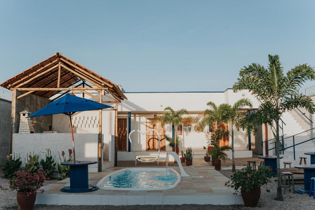 a patio with a pool and an umbrella and a table at Lounge Pdd - Espaço inteiro in Aquiraz