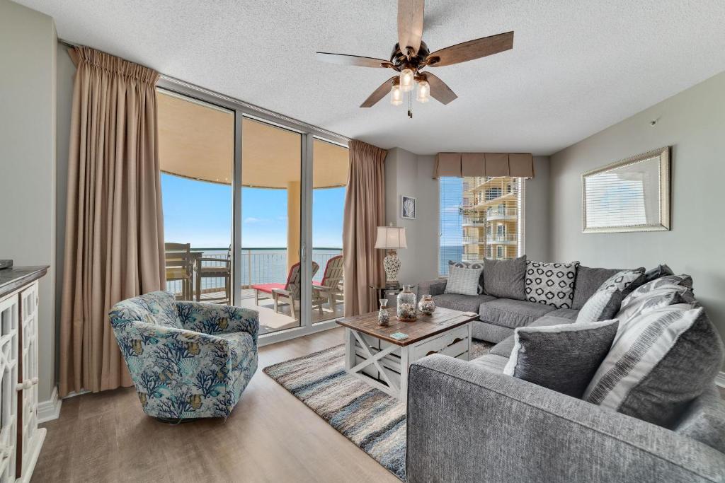 a living room with a couch and chairs and a ceiling fan at Beach Colony East 15C-Penthouse in Perdido Key