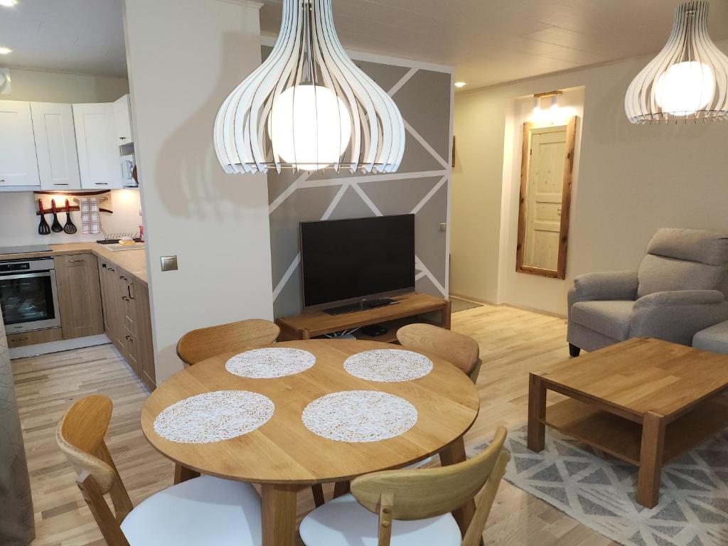 a living room with a dining room table and a kitchen at Kuuse 4 Apartment in Haapsalu