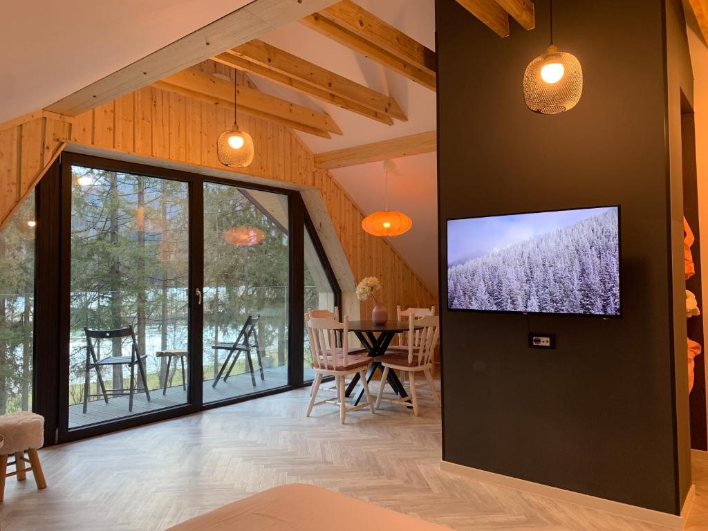 sala de estar con TV de pantalla plana en la pared en Pine Tree Holiday House, en Gozd Martuljek