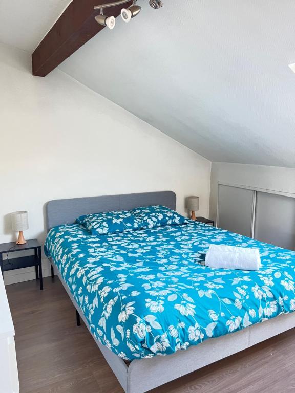 a bedroom with a bed with a blue blanket at Pin's - Magnifique appartement in Sarrebourg