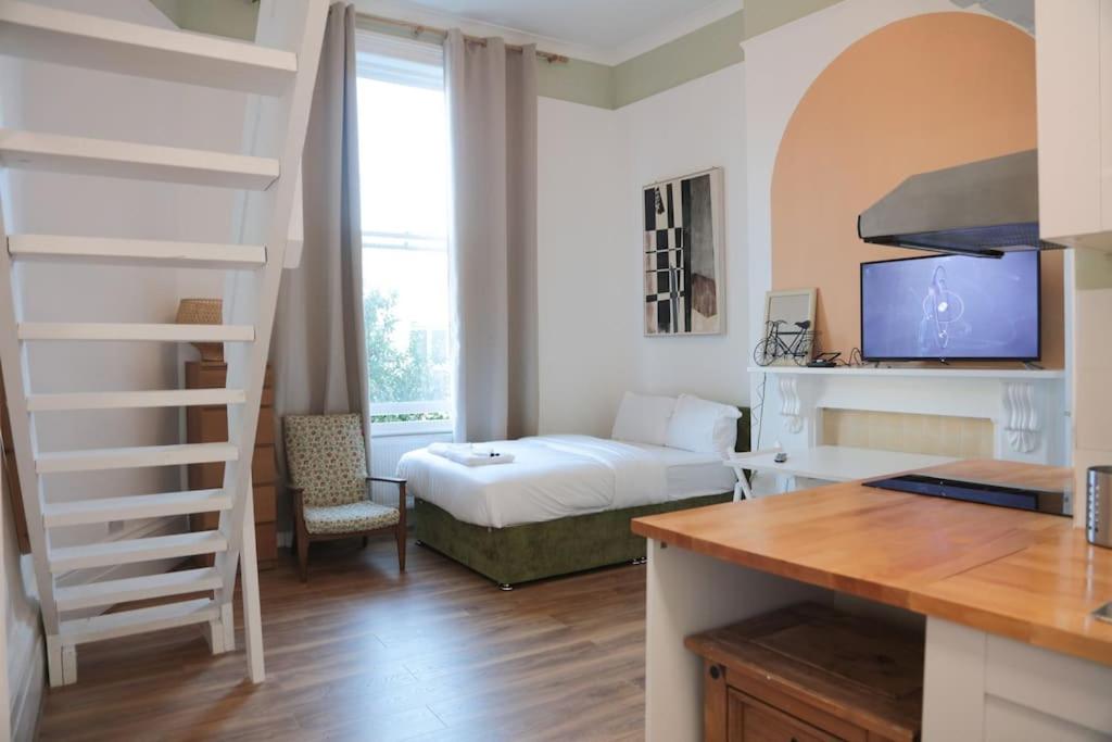 a small room with a bed and a room with a desk at Sunlight Studio in King's Cross in London