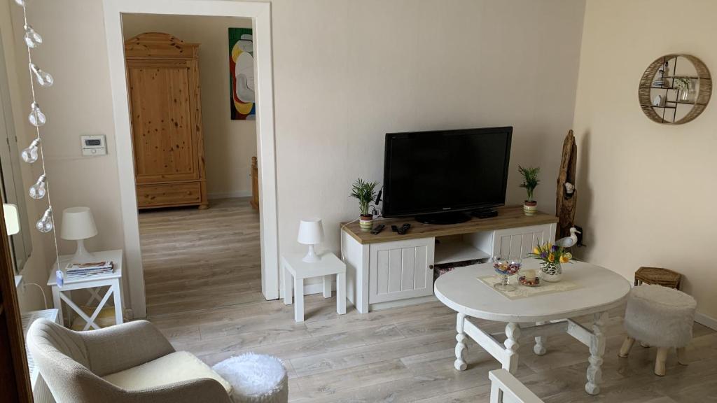 ein Wohnzimmer mit einem TV und einem Tisch in der Unterkunft Ferienhaus Cornelia in Koblenz