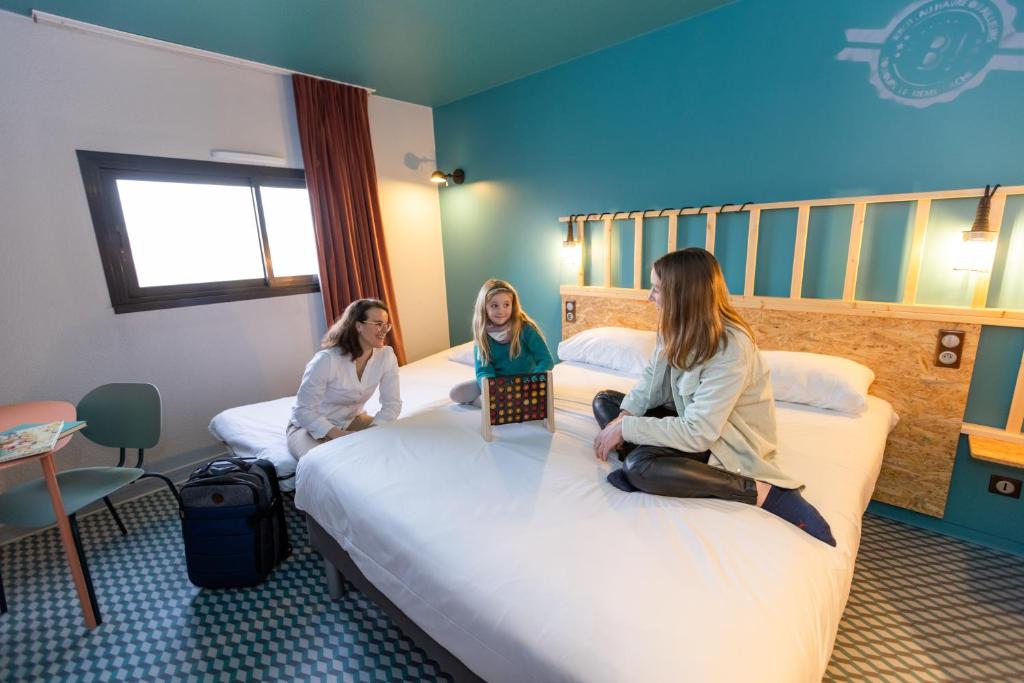 two girls sitting on beds in a hotel room at Birgit Hôtel Le Havre Centre in Le Havre