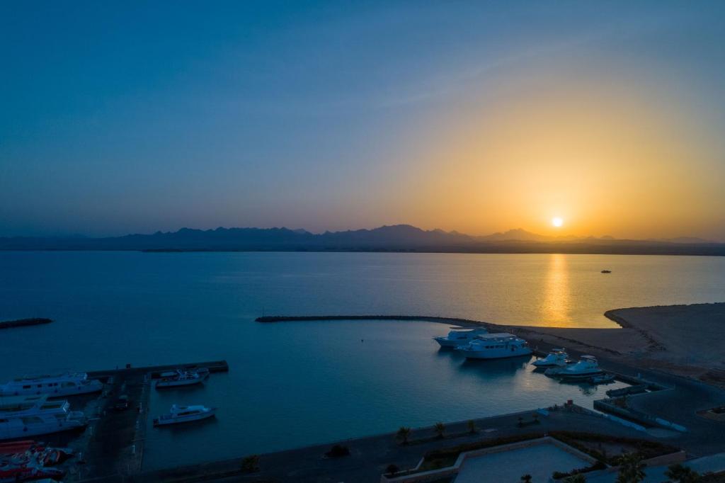 a sunset over a body of water with boats at Stayr Somabay - Bay Life Home Rentals in Hurghada