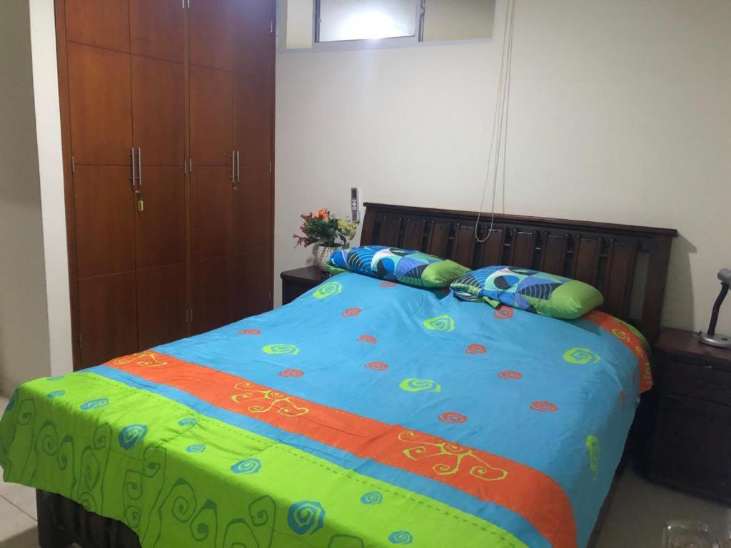 a bed with a colorful comforter and pillows on it at Apartamento para 5 in Barranquilla