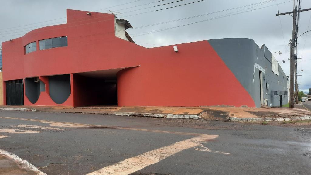 ein rotes Gebäude auf der Straßenseite in der Unterkunft MOTEL HORA EXTRA in Jataí