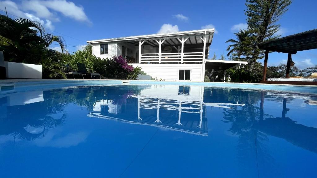 - une piscine en face d'une maison dans l'établissement Villa Cristalline Douceur des Alizés, à Belle-Allée
