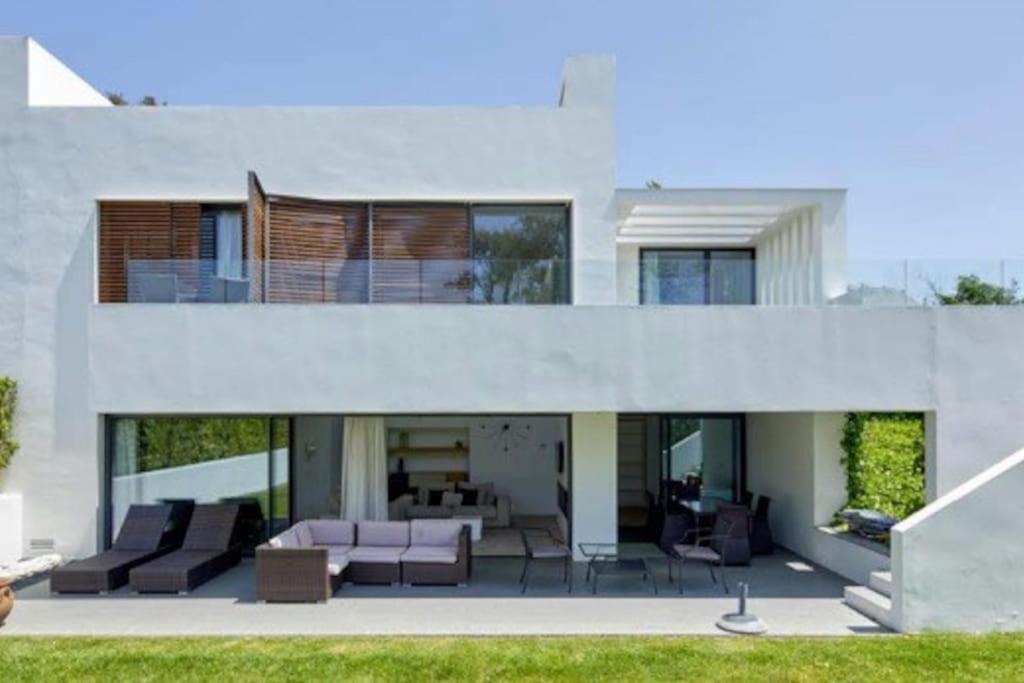 a large white house with a couch and chairs at Camiral Golf and Wellness Luxury Villa in Girona