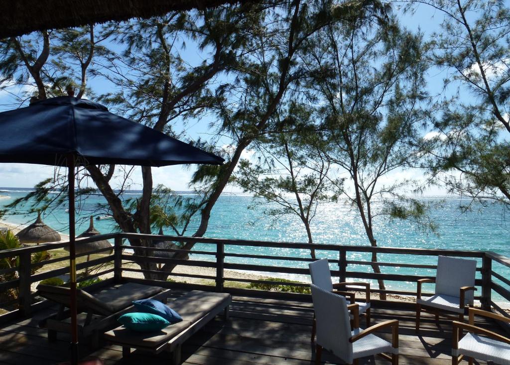 tavolo e sedie con ombrellone e oceano di BlueMoon Villa on The Beach a Trou d'Eau Douce