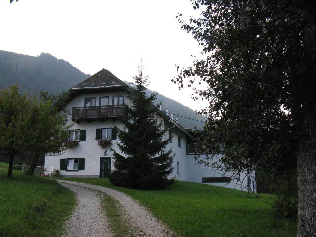 a house with a tree in front of a dirt road at Haus Rottenstein in Neukirchen