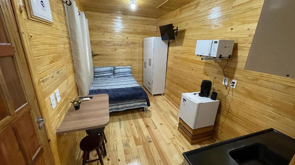 um pequeno quarto com uma cama e um lavatório em Lindos e novos Chalés na região central de Foz em Foz do Iguaçu