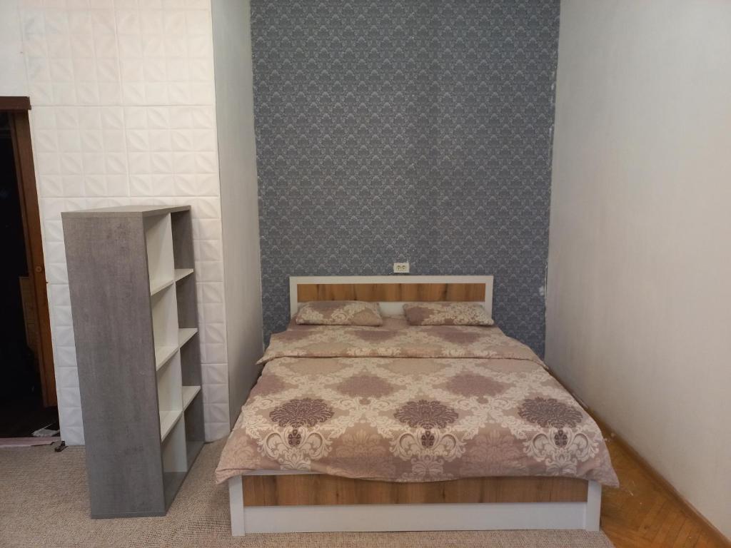 ein Schlafzimmer mit einem Bett und einem Bücherregal in der Unterkunft 1к квартира Антоновича. Олімпійська in Kiew