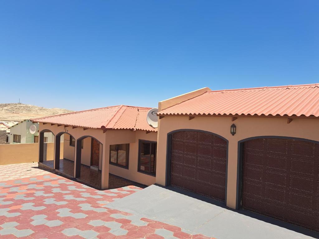 une maison avec deux portes de garage et un toit en carrelage dans l'établissement JJP SELF CATERING - Three bedroom house, à Lüderitz