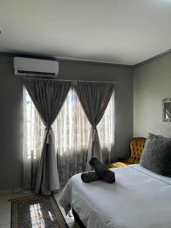 Un dormitorio con una cama grande y una ventana en Jobe Guesthouse, en Pietermaritzburg