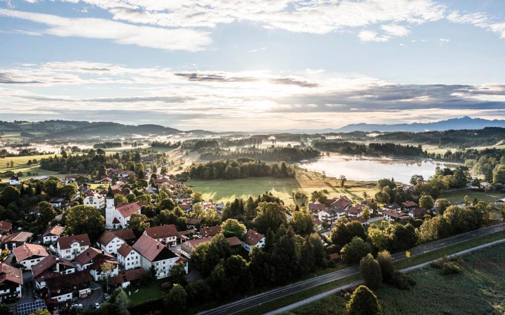 an aerial view of a town with a river and houses at Parkhotel am Soier See in Bayersoien