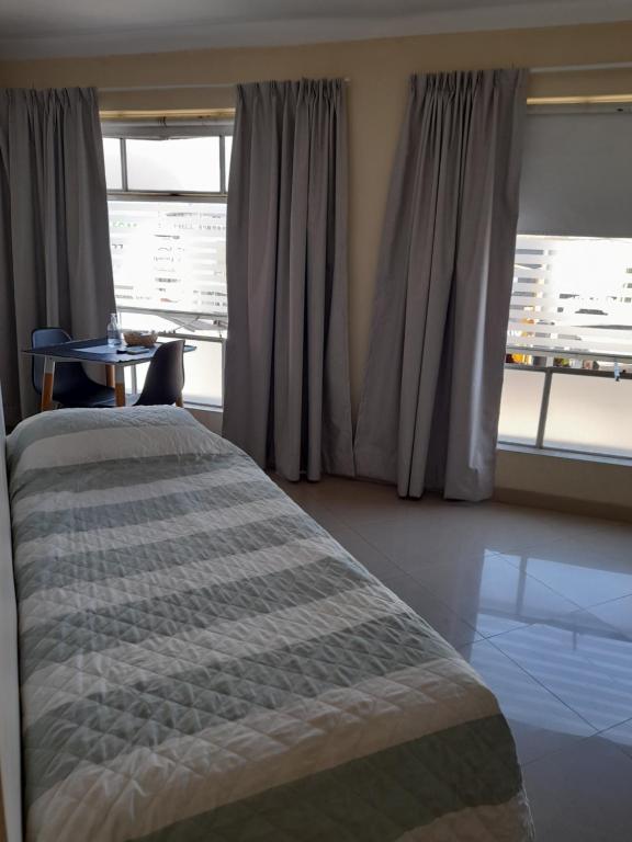 Schlafzimmer mit einem Bett, einem Tisch und einem Fenster in der Unterkunft Departamento Peatonal in Paraná