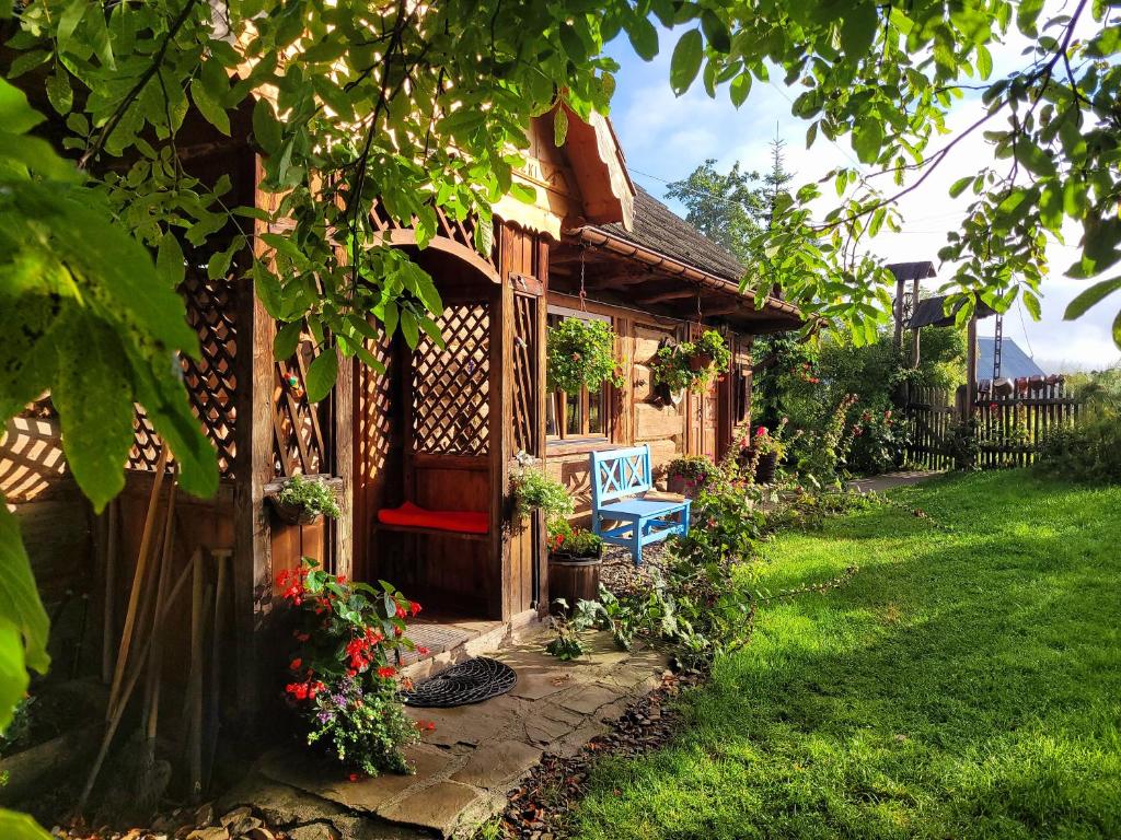 a wooden house with a bench in a yard at Przytulia willa in Stryszawa