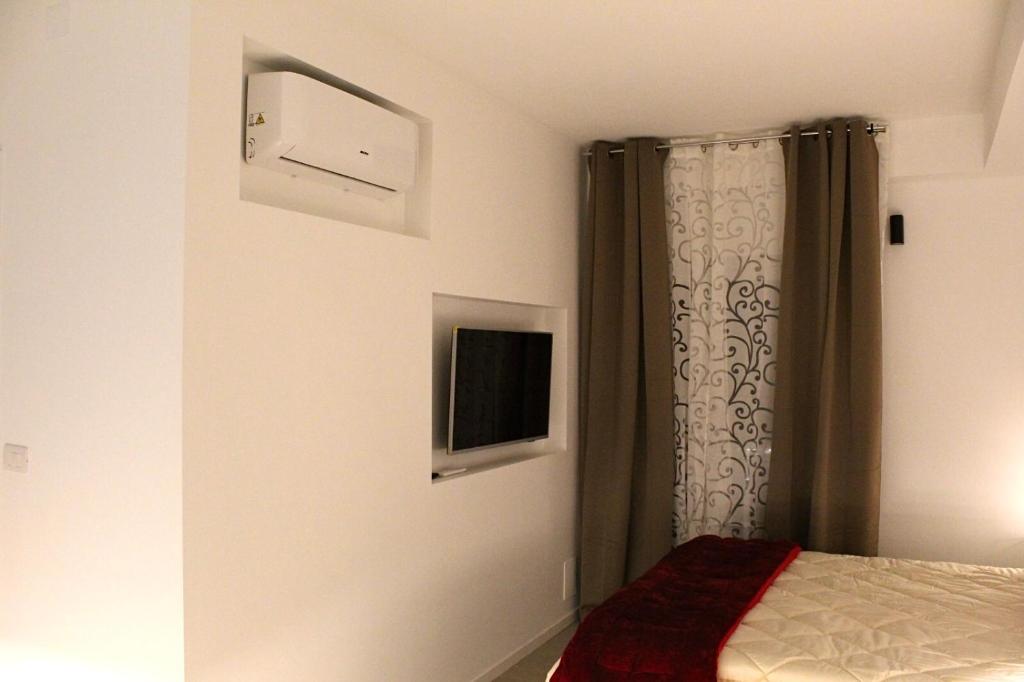 a bedroom with a bed and a window with a curtain at Archimar House in Taranto