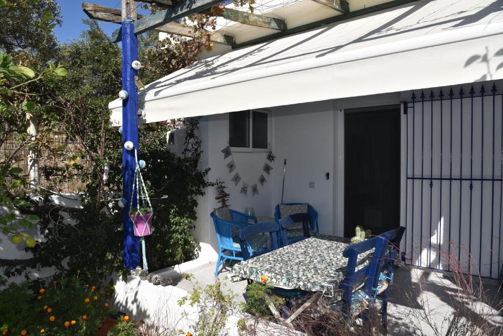 une terrasse avec des chaises bleues et une table sur une maison dans l'établissement Relaxing and Comfortable Studio Near Falasarna Beaches, à Plátanos