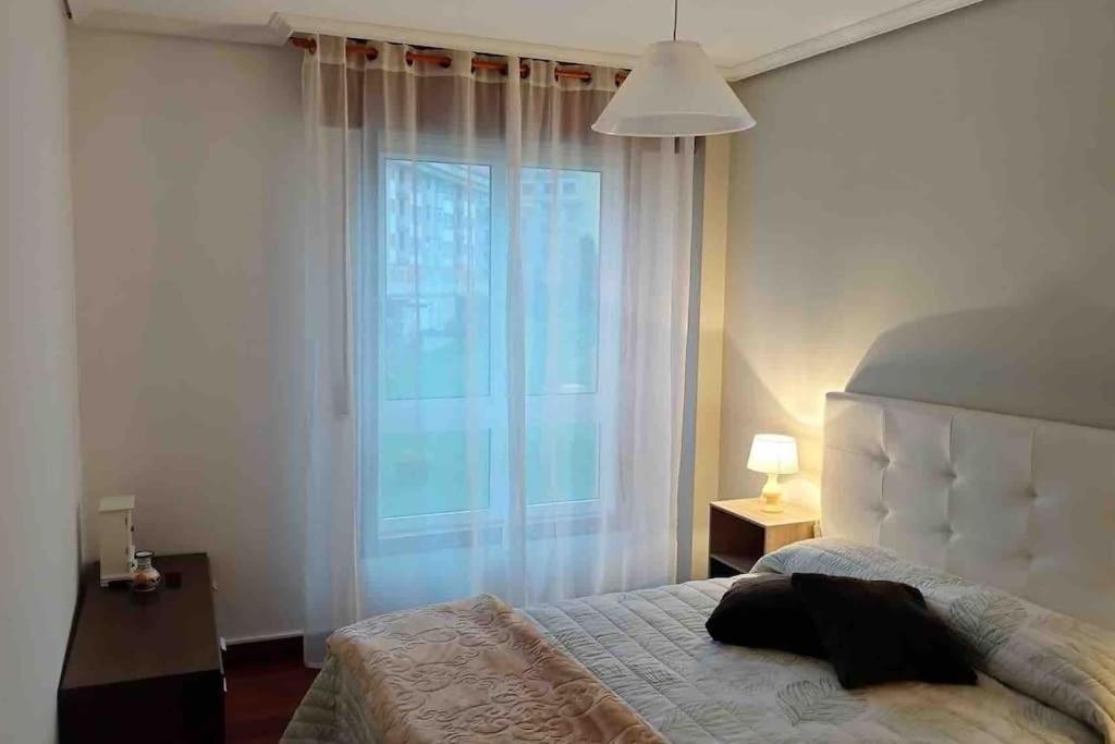 a bedroom with a bed and a large window at O Fogar in Moaña