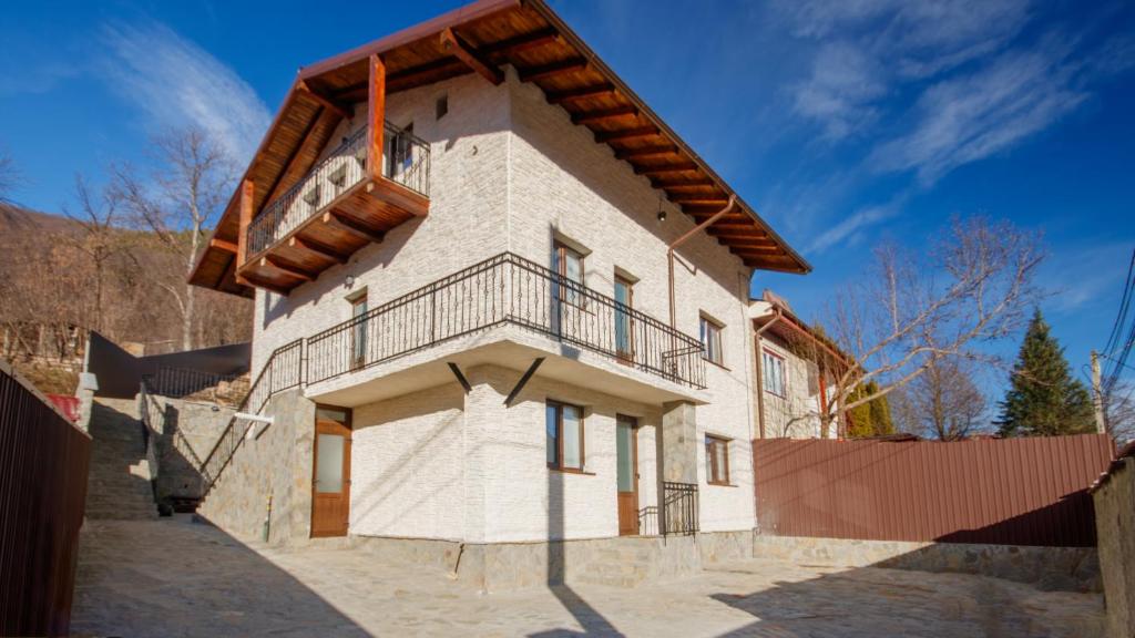 a house with a balcony on the side of it at Casa Zânelor Slănic Moldova in Slănic-Moldova