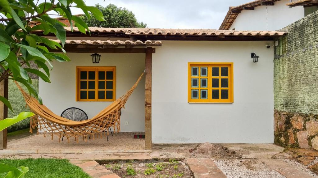 a hammock on the side of a house at Casa Sabiá - Lençóis/BA in Lençóis