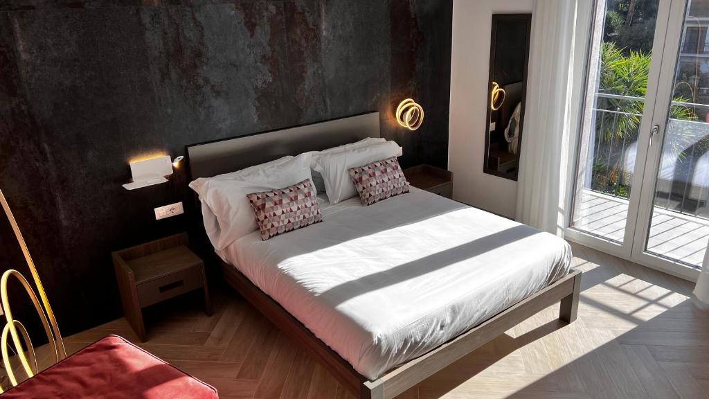 um quarto com uma cama com lençóis brancos e almofadas em Patriziella 4 Rooms em Sorrento