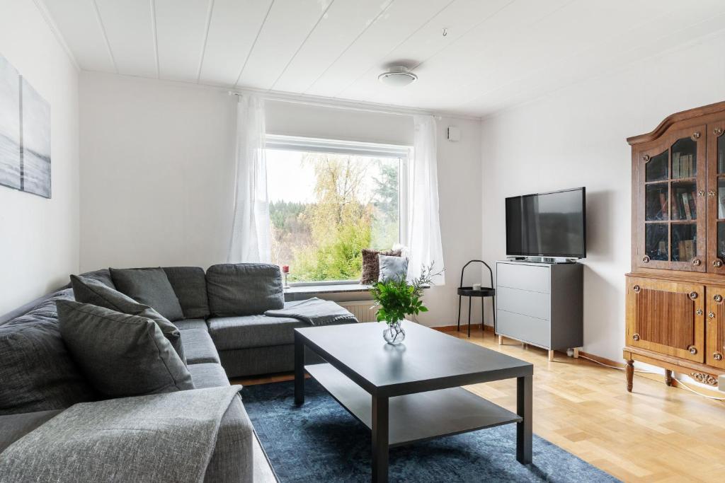 a living room with a couch and a tv at Peaceful holiday home surrounded by nature in Töllsjö