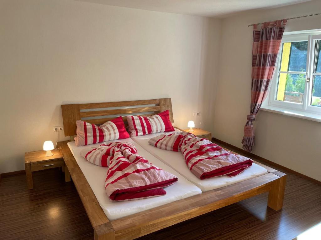 - une chambre avec un lit doté d'oreillers rouges et blancs dans l'établissement Ferienwohnung Bernhardiner, à Nauders