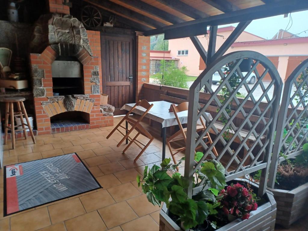 a patio with a table and a brick fireplace at Pension Pawlak in Tauche