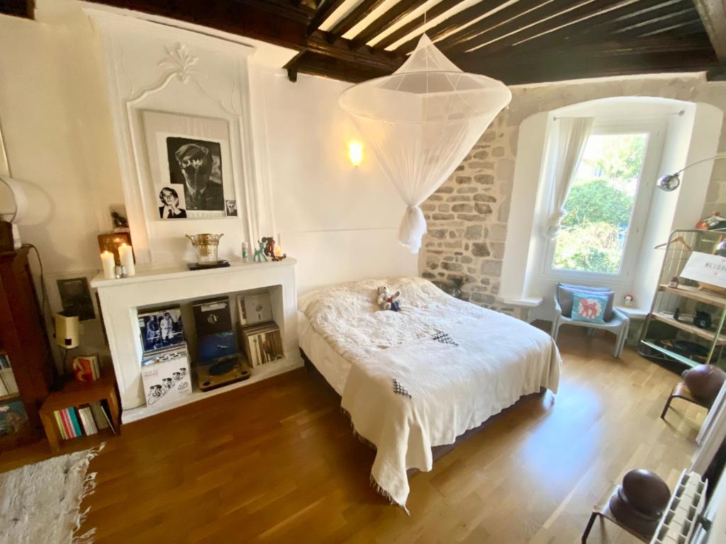 a bedroom with a bed with a white comforter at La Suite Sainte Claire in Hyères