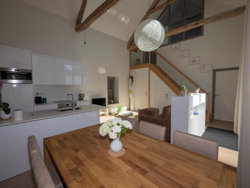 a kitchen and dining room with a wooden table with flowers at Gite Oliveira&#39;s in Ury