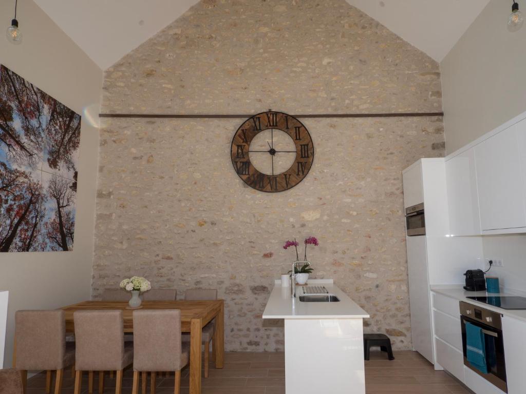 a kitchen and dining room with a clock on the wall at Gite Oliveira&#39;s in Ury