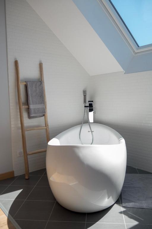 a white bath tub in a bathroom with a skylight at Gite Oliveira&#39;s in Ury