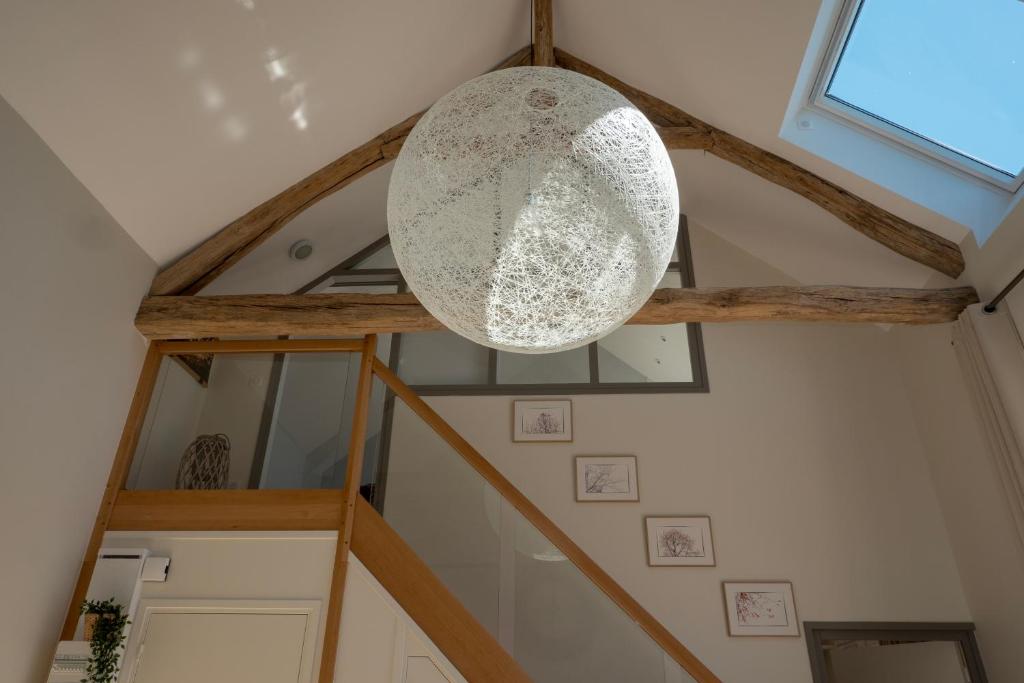 a ceiling light in a room with wooden beams at Gite Oliveira&#39;s in Ury