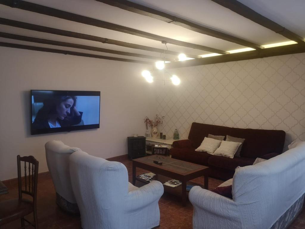 salon z 2 krzesłami, kanapą i telewizorem w obiekcie Casa da Carballeira w mieście A Estrada