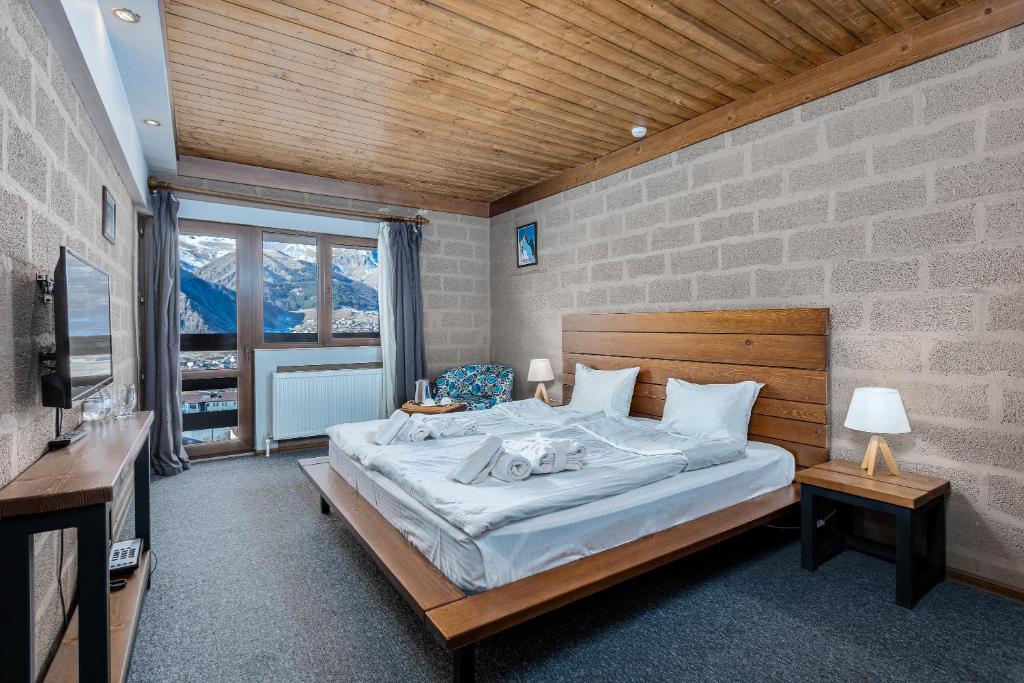 a bedroom with a large bed in a room at Alpine Lounge Kazbegi in Stepantsminda