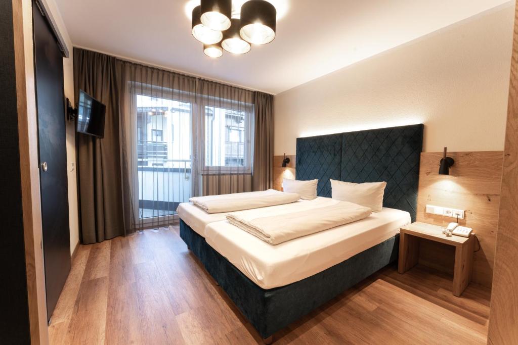 Postel nebo postele na pokoji v ubytování Aparthotel Dorfplatzl Garni