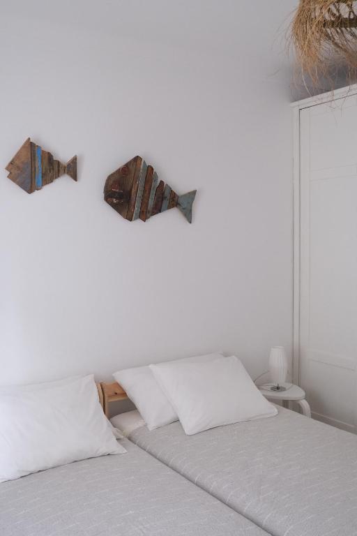 1 dormitorio con 1 cama con 2 peces en la pared en Oliveira Beach House, en Longueira