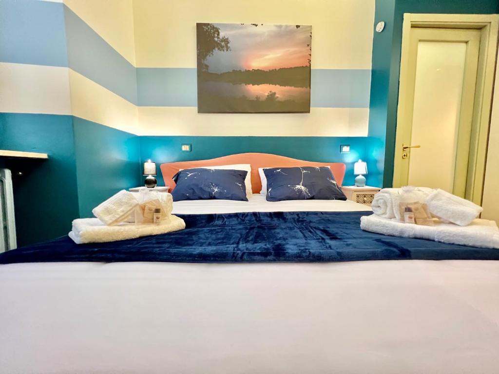 1 dormitorio con 1 cama grande y paredes azules en Novantasette passi dal Duomo, en Casale Monferrato
