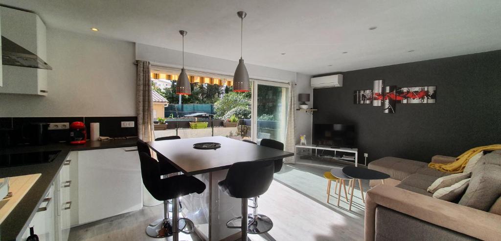 a kitchen and living room with a table and chairs at Le Silène in Sainte-Maxime