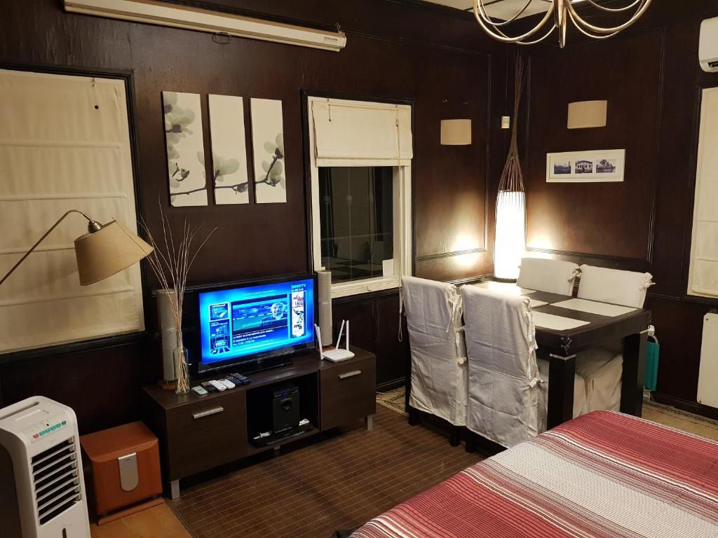 um quarto com uma televisão, uma secretária e uma cama em Islavinia em Tigre