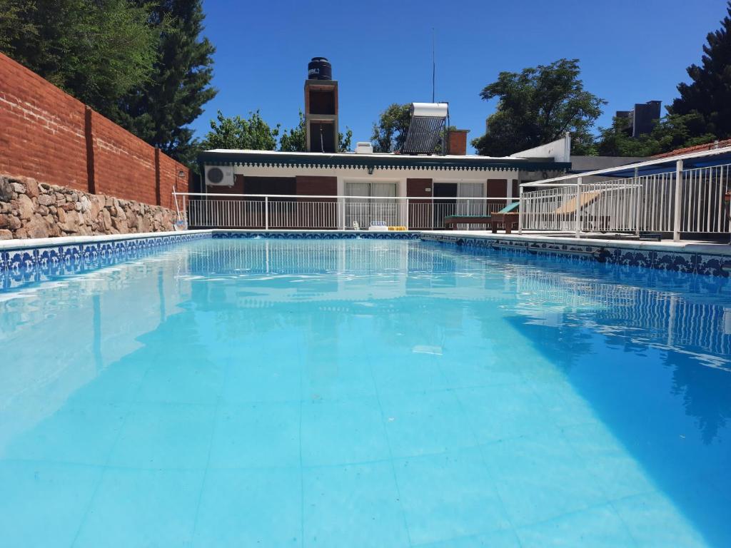 una gran piscina azul con un edificio en el fondo en Cabaña El Hornero en Mina Clavero