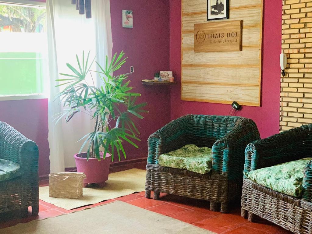 a living room with two chairs and a plant at Ville Sweet Home in Canoa Quebrada