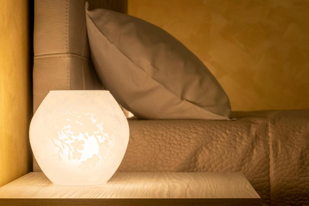 米蘭的住宿－Leader Apartment 3，白色的花瓶坐在带枕头的沙发上
