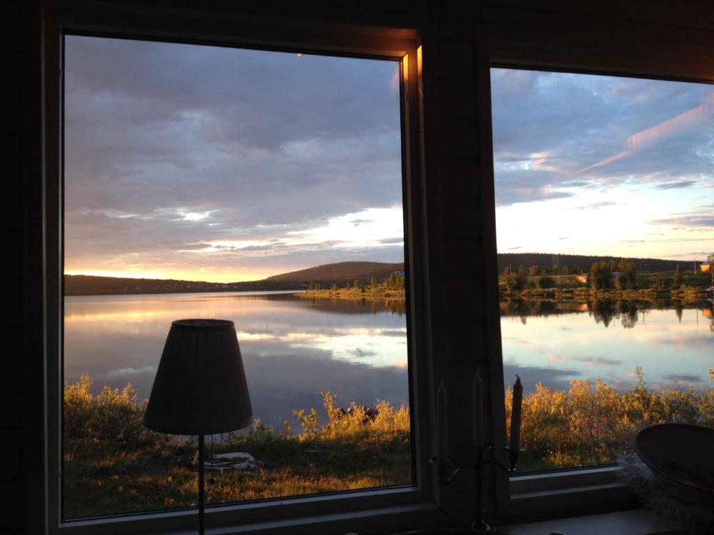 a view of a lake from a window with a lamp at Lakeside cottage in Lapland with great view in Skaulo