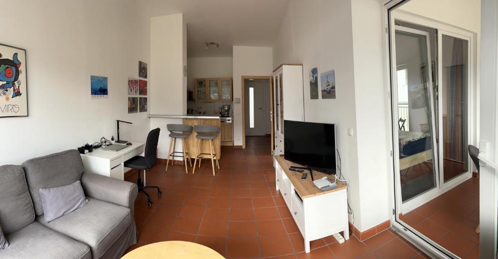 ein Wohnzimmer mit einem Sofa und einem Flachbild-TV in der Unterkunft Ferienwohnung Kronegarten in Gmunden