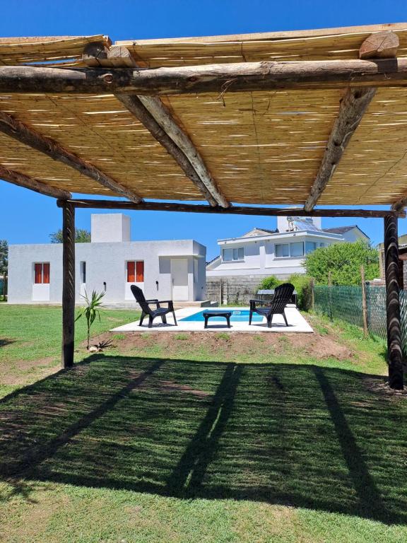 San Roque的住宿－CABAÑA LA HERRADURA 14，一个带2个长椅和游泳池的木制凉亭