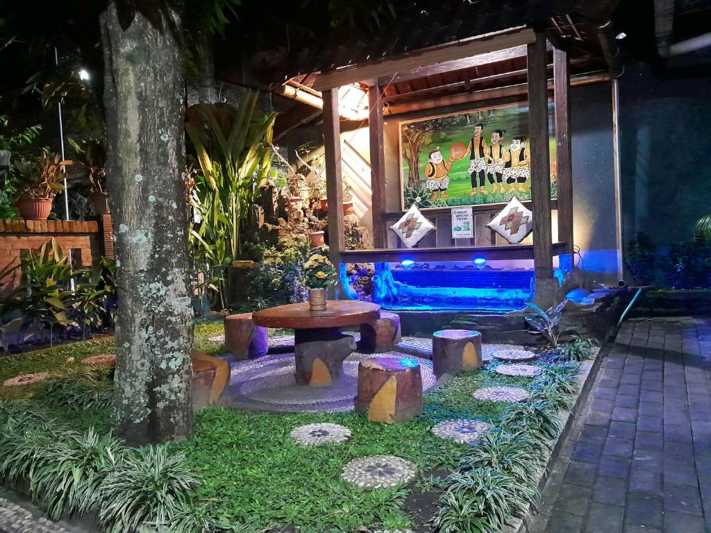 un giardino con tavolo e cartello di Ngampilan Backpacker Hostel a Yogyakarta